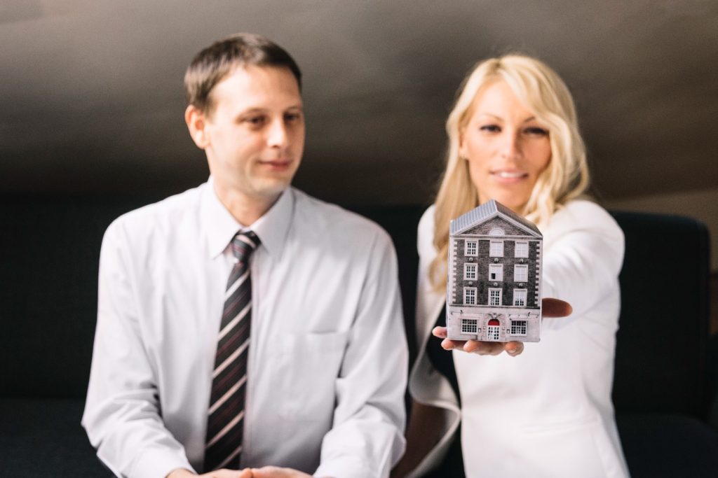 real estate agent holding toy house (1)